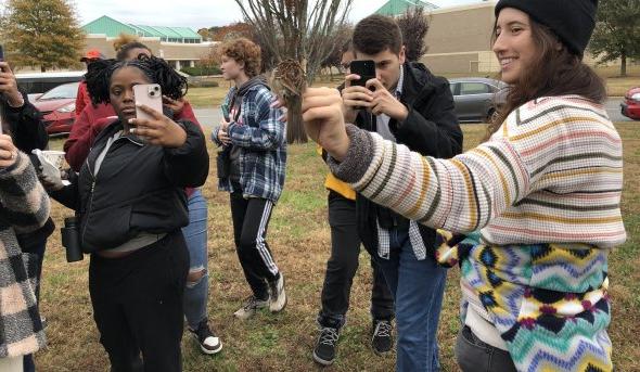 a woman holds a bird while others take photos 